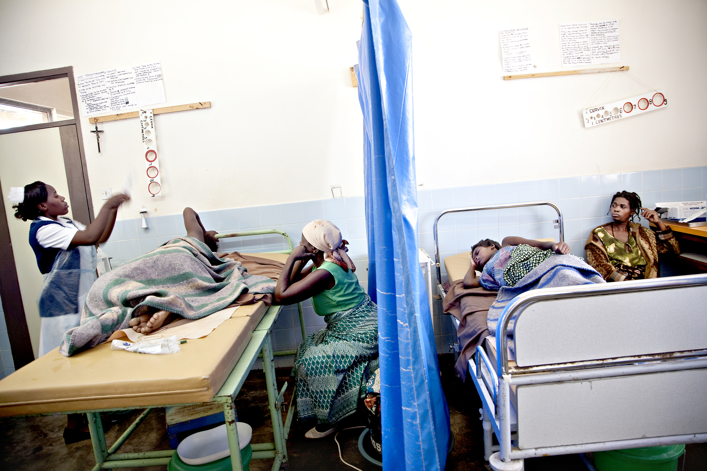 St. Joseph’s Hospital, Chiradzulu, Malawi, 2010: På hver sin side av et blått plastikkforheng ligger Chrissy Andrew (34) og Modester Mosamba (16) og føder. Andrew har fire barn fra før, men dette svangerskapet ble annerledes. På kontroll fikk hun vite at hun er hivpositiv.